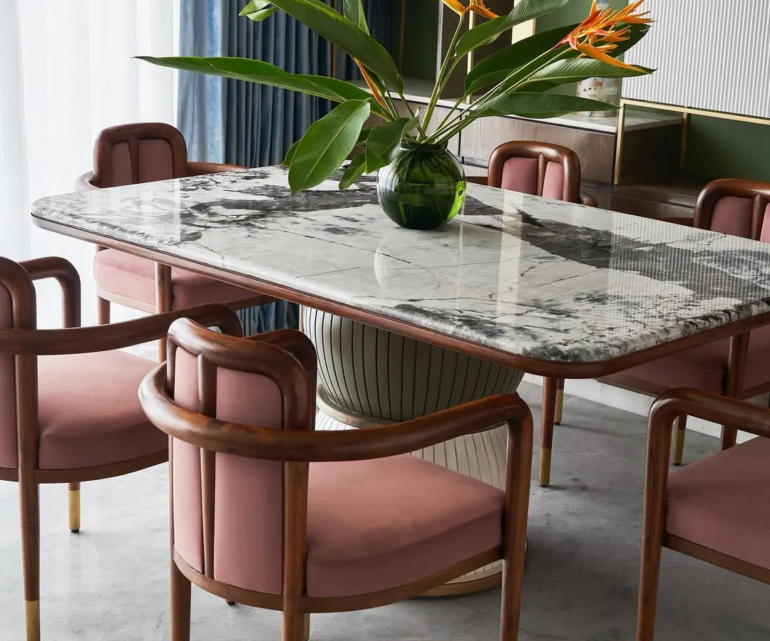 Meet the “Pellet Drum” dining table, a piece inspired by the form of Shiva’s damru. Its base features grooved spheres finished in dual-tone polyurethane, supporting a magnificent Patagonia marble top. Paired with our bent teakwood 'Svelte' chairs, this set makes every meal a statement.
