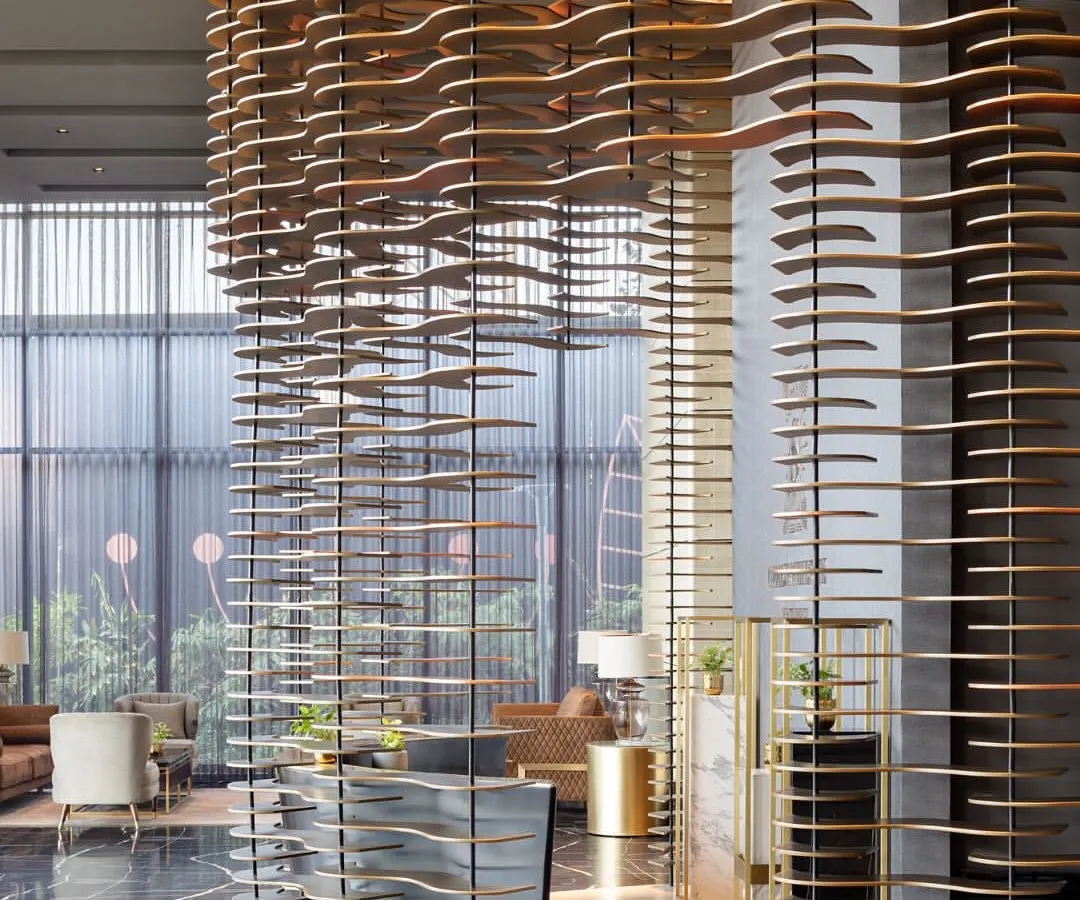 For the Godrej South Estate Experience Centre, we created a design that is an experience in itself. This semi-permeable, curved installation acts as a majestic curtain, balancing openness with intrigue. Crafted from layered MDF plates and illuminated by narrow-beam lights, it transforms a structural element into a piece of art, guiding visitors through a narrative of luxury.