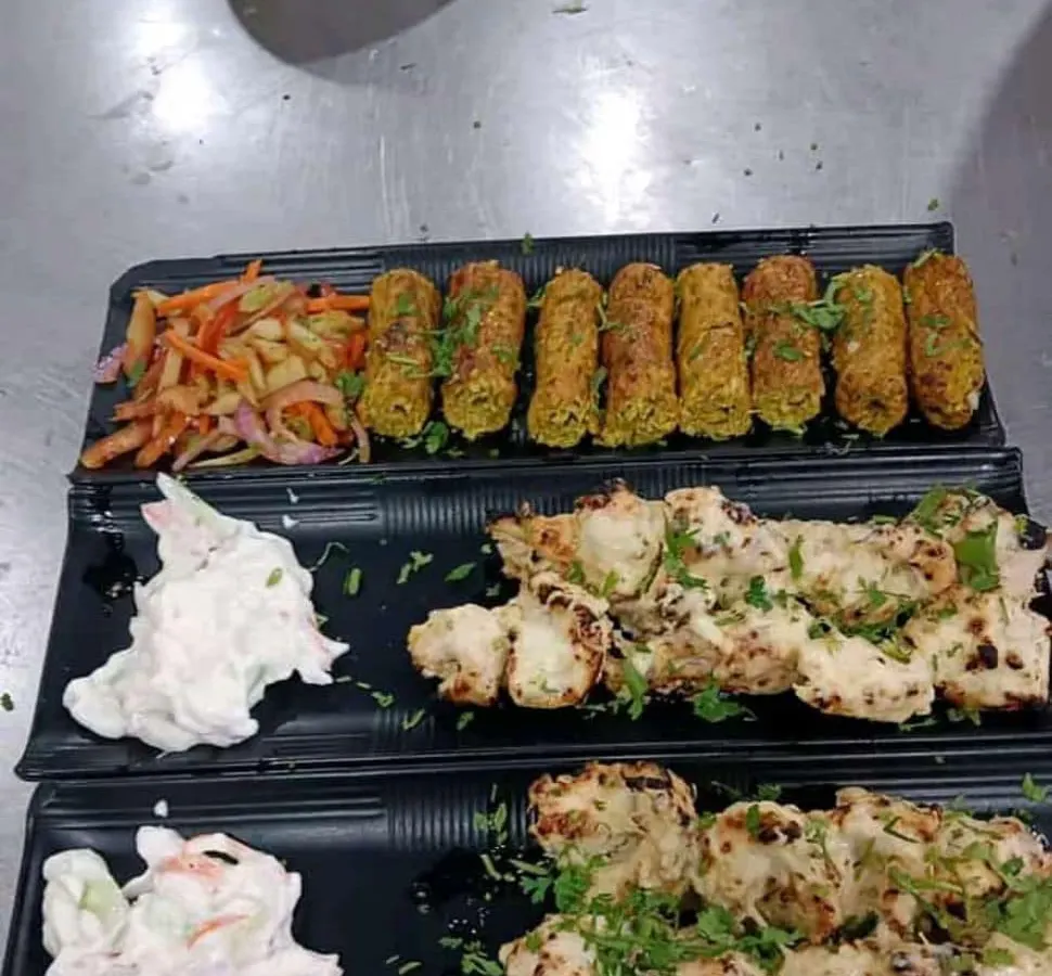 A platter of our freshly prepared appetizers, featuring succulent chicken malai tikka and flavorful vegetable seekh kebabs. This is an example of the quality and presentation we bring to every corporate meal or event.