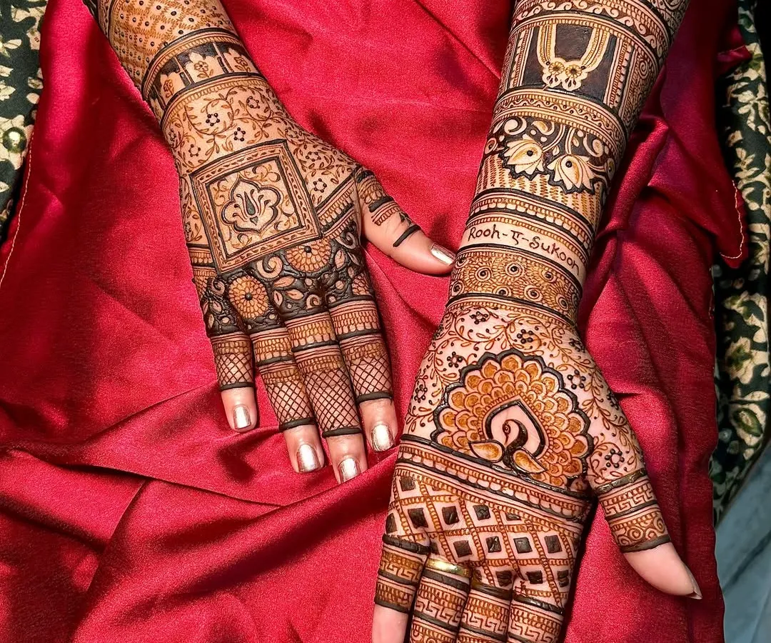 I love the challenge of creating two unique yet complementary designs for a bride. This set features a traditional peacock motif on one hand and a geometric pattern with lotus details on the other, both extending up the arm for a complete bridal look.