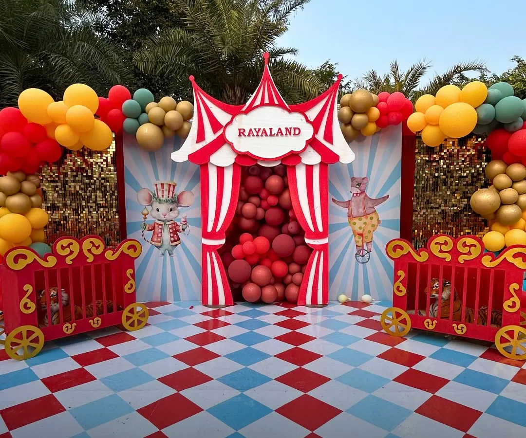 Welcome to 'Rayaland'! For this grand first birthday, we created a full-scale circus theme outdoors. From the custom entrance and character props to the vibrant balloon arrangements and checkered flooring, we handled every detail to create a joyful, immersive world for the little one and their guests.