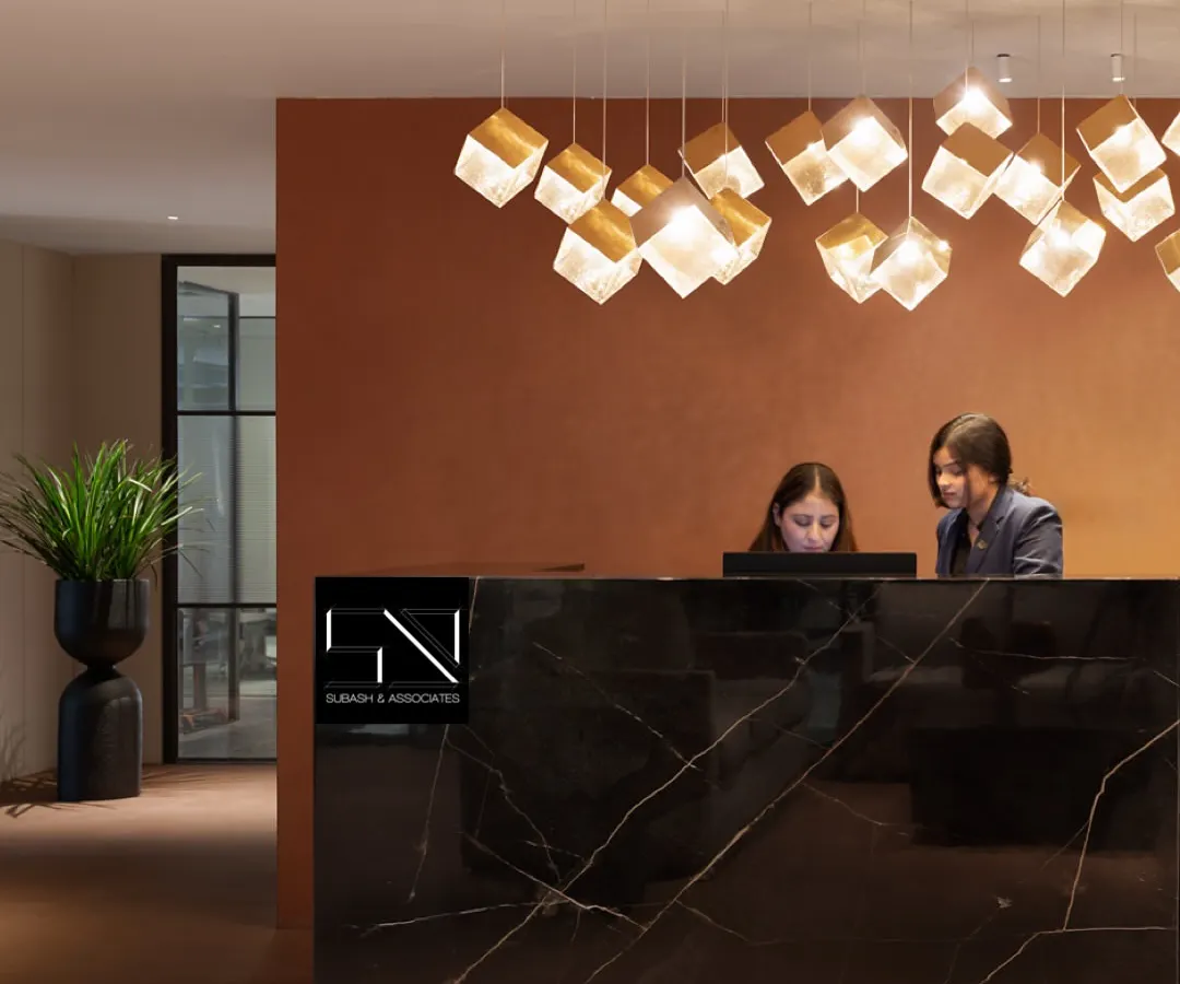 The reception at Jubilee Walk Headquarters, designed to be the first point of contact with the brand's ethos. The solid black marble desk, complemented by a cascade of geometric pendant lights, establishes an immediate sense of modern luxury and professionalism.