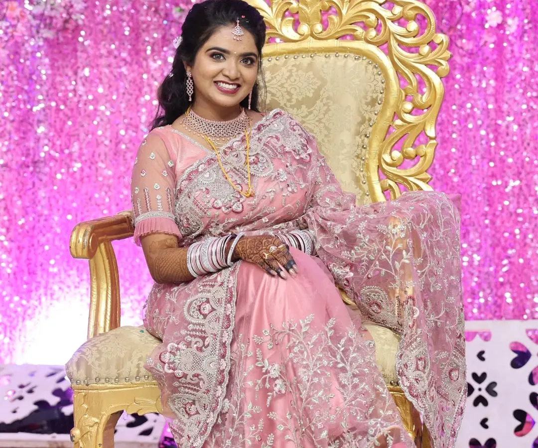 Here is one of our beautiful clients looking radiant on her reception day. She is wearing a modern American Diamond (AD) necklace set that sparkles beautifully under the lights. This set includes a layered choker and matching earrings, providing a glamorous look for contemporary events.