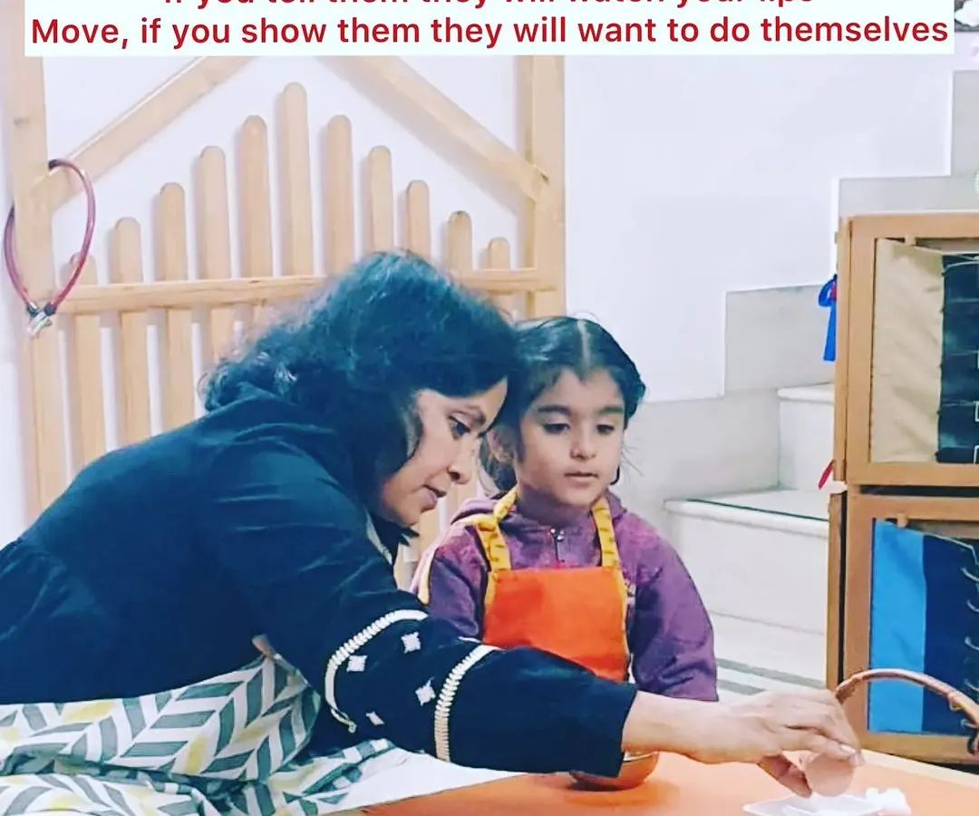 Our guiding principle is "Show them, don't tell them." In our prepared environment, a teacher gently demonstrates a practical life activity, allowing the child to observe and learn through action, not just words. This fosters deep concentration and a love for learning.