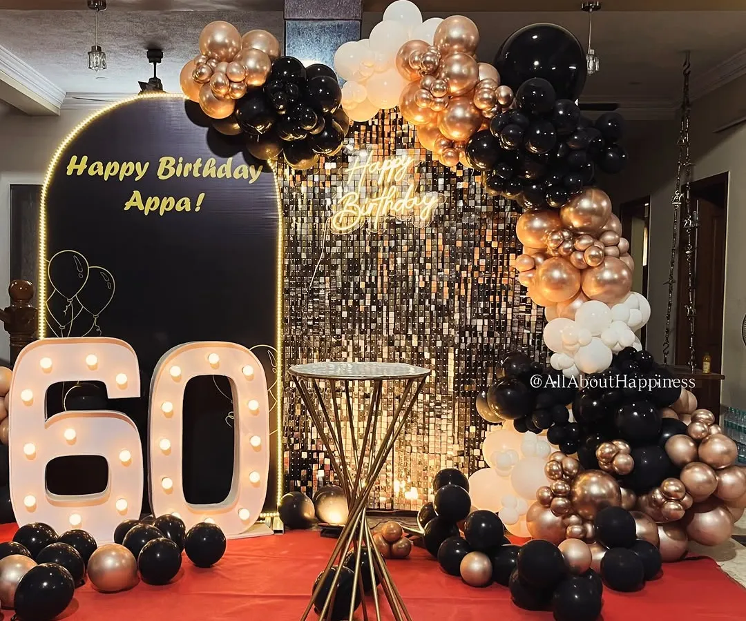 We love a glamorous milestone! For this 60th birthday, we combined a full-stage shimmer wall with a custom 'Happy Birthday Appa' arch, bold marquee numbers, and a rich black and gold balloon garland to create a sophisticated and celebratory atmosphere.