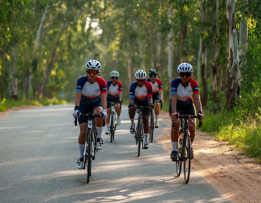 Sisterhood on the road. This is what we're all about. A group of us riding in formation through the scenic roads near Nandi Hills, all wearing our 'Mountains Are Calling' club kit. This is performance athletic apparel that unites us as a team.