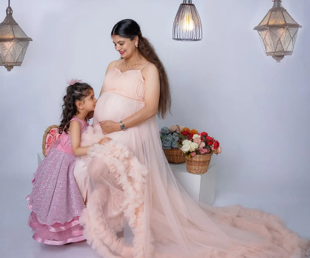 The bond between a mother and her child begins long before they meet. Here, a soon-to-be big sister shares a quiet, precious moment with her mother, whispering secrets to the baby on the way.