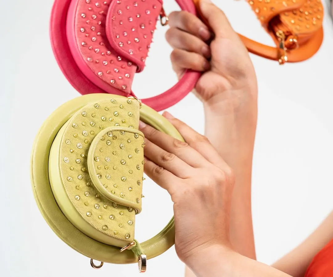My Candy Floss mini bags are all about having fun with fashion. This image shows a few of the vibrant, playful colours available, each with a unique circular handle and delicate stud detailing.