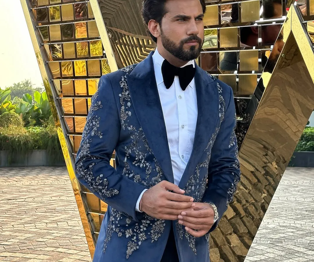 Make an unforgettable entrance with our hand-embroidered Nacre Tuxedo. The deep navy blue velvet provides a rich canvas for the intricate floral embroidery, creating a masterpiece of formal wear for weddings and galas.