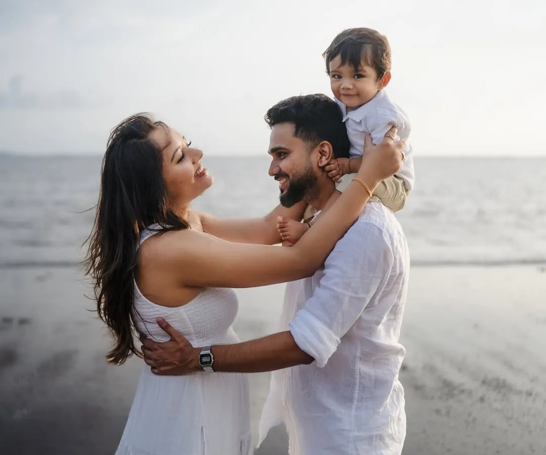 There's nothing like the joy of a growing family. This candid moment on the beach, with a happy toddler on his dad's shoulders, perfectly captures the love and excitement before a new arrival.