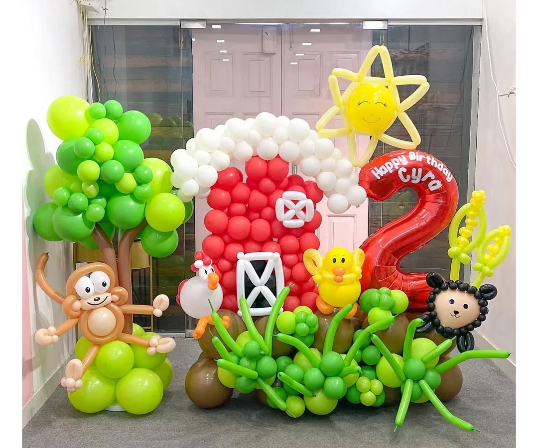 I love bringing entire worlds to life, like this farm-themed sculpture for a second birthday. It features a whole cast of characters including a cheeky monkey, a happy sun, and a red barn, all meticulously crafted from balloons to create an immersive party scene.