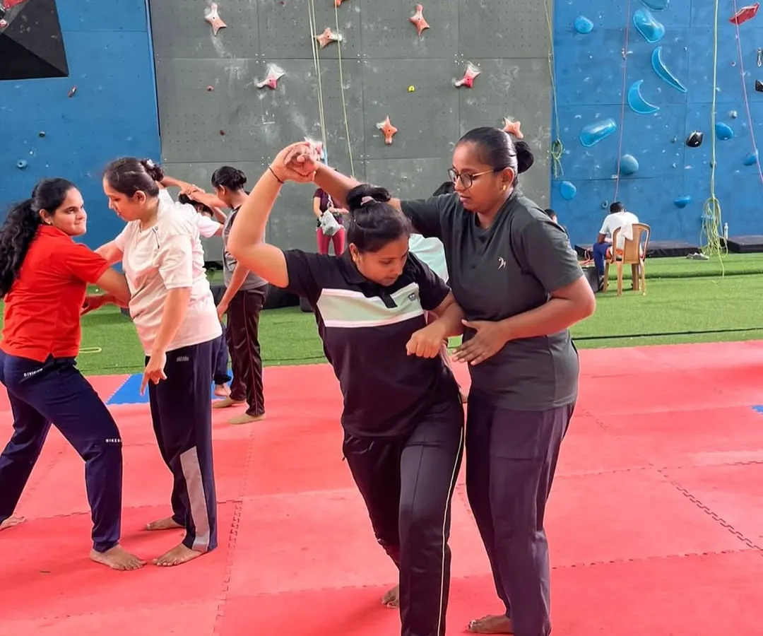 Our instructors provide personalized, hands-on guidance during every session. Here, an instructor corrects a participant's form on a wrist-hold escape, ensuring the technique is learned correctly and can be applied effectively in a real-life situation.