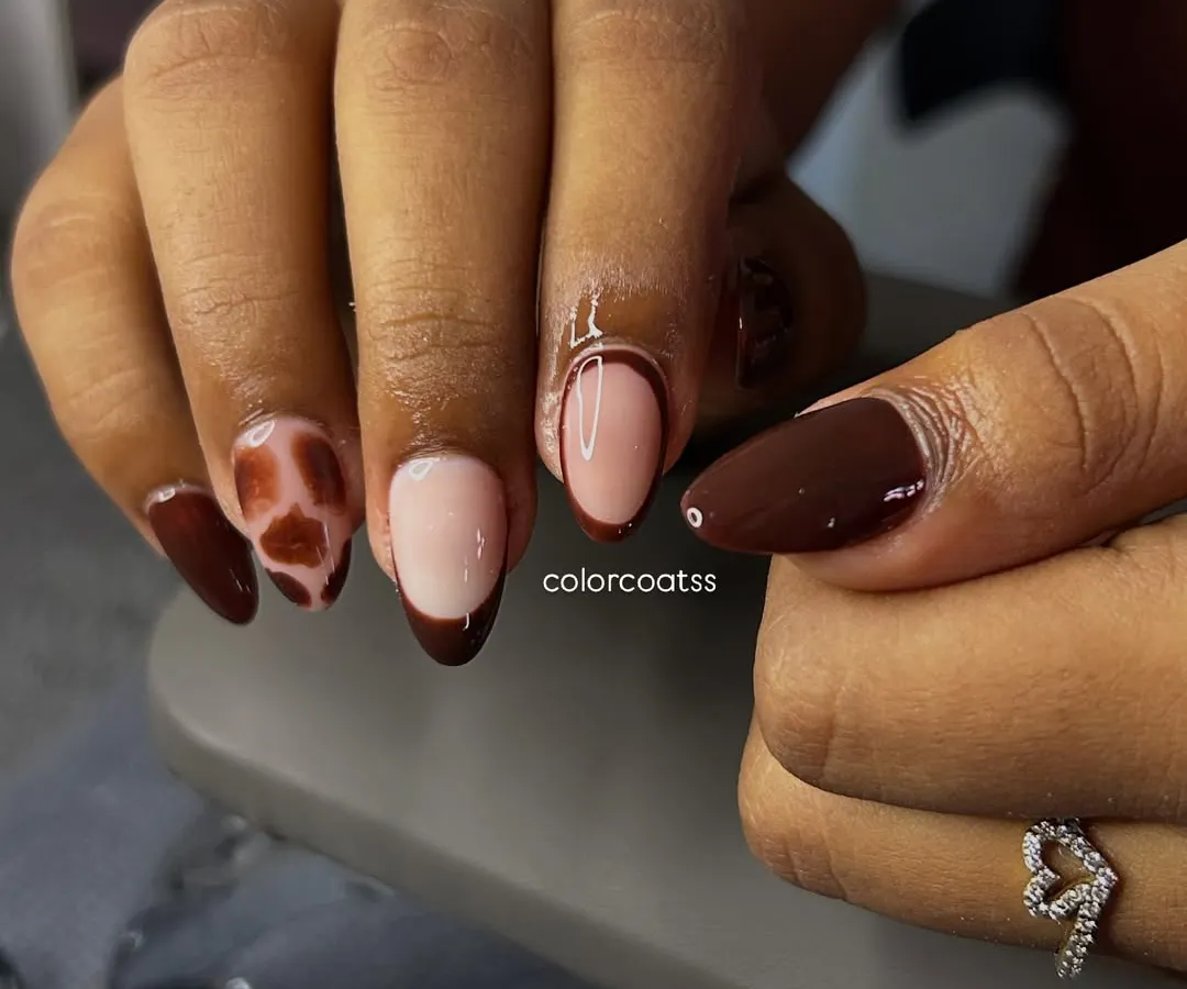 A close-up of one of my favorite custom designs. This set combines a rich chocolate brown French tip with a trendy tortoiseshell animal print on almond-shaped extensions, creating a look that's both fierce and chic.