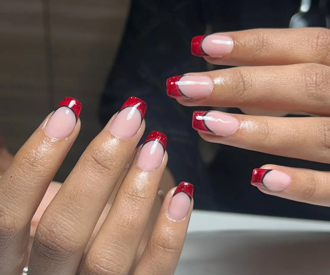 A classic French manicure, but make it bold. These red glitter French tips are for when you want to feel powerful and a little bit dangerous. This is a structured gel overlay on natural nails.