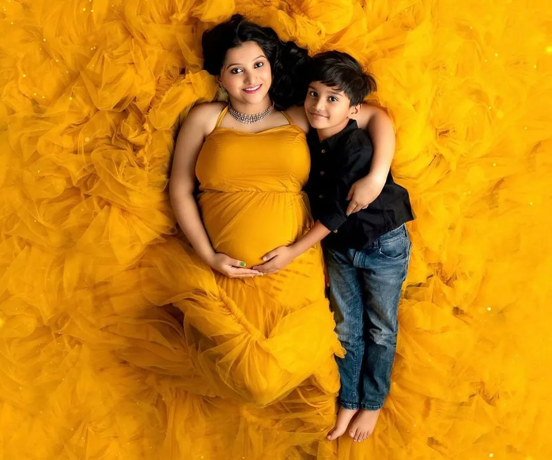 The journey to motherhood is a universe of its own. This stunning overhead shot celebrates the beauty and power of a mother-to-be, wrapped in a vibrant gown that's as full of life as she is.