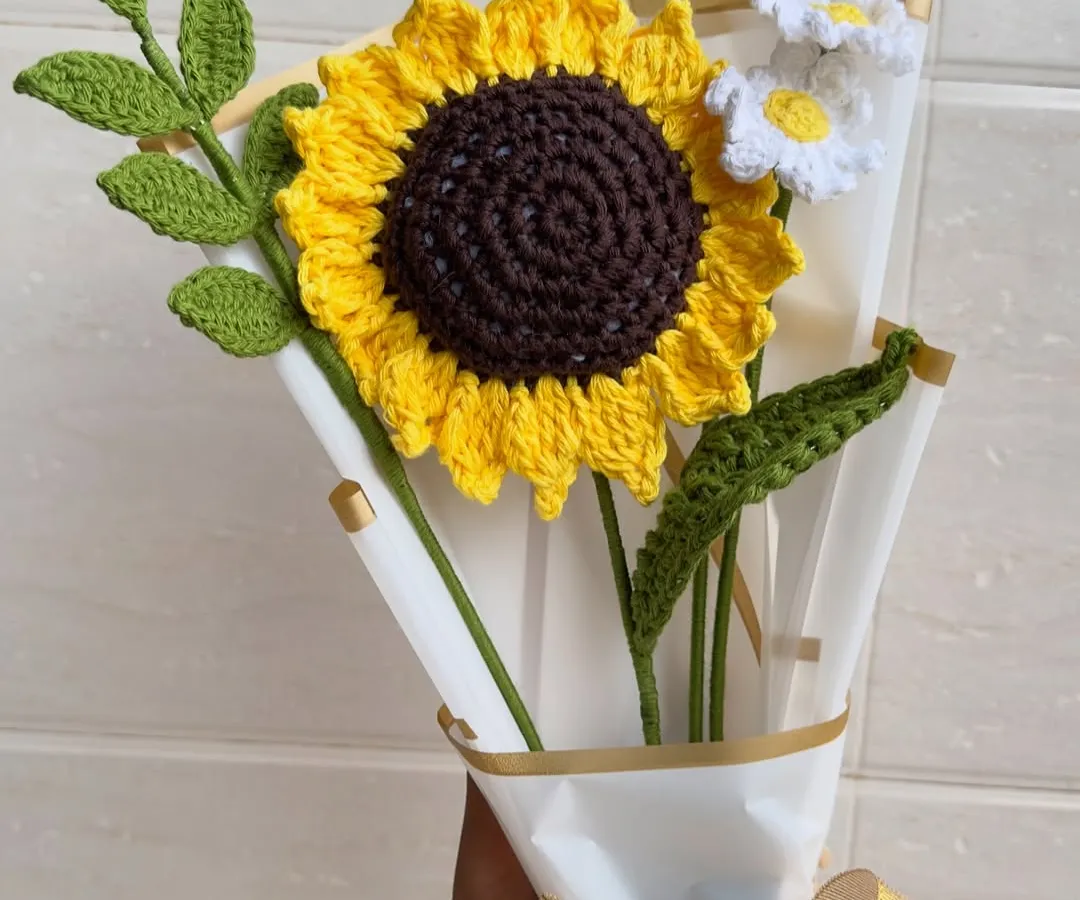 Brighten up any room with our handmade crochet sunflower and daisy bouquet. These "forever flowers" are crafted with vibrant yellow and white yarn, complete with detailed green leaves, and wrapped beautifully for the perfect, lasting gift.