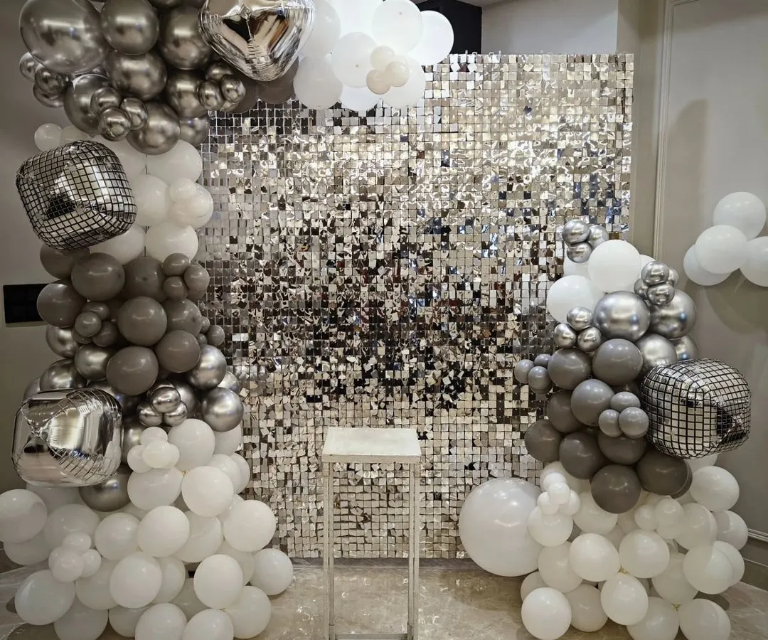 For a modern and glamorous party, we offer this stunning silver shimmer wall. Paired with organic balloon columns in white, grey, and chrome, and accented with disco ball foil balloons, this backdrop is guaranteed to make your bachelorette or birthday party photos pop.