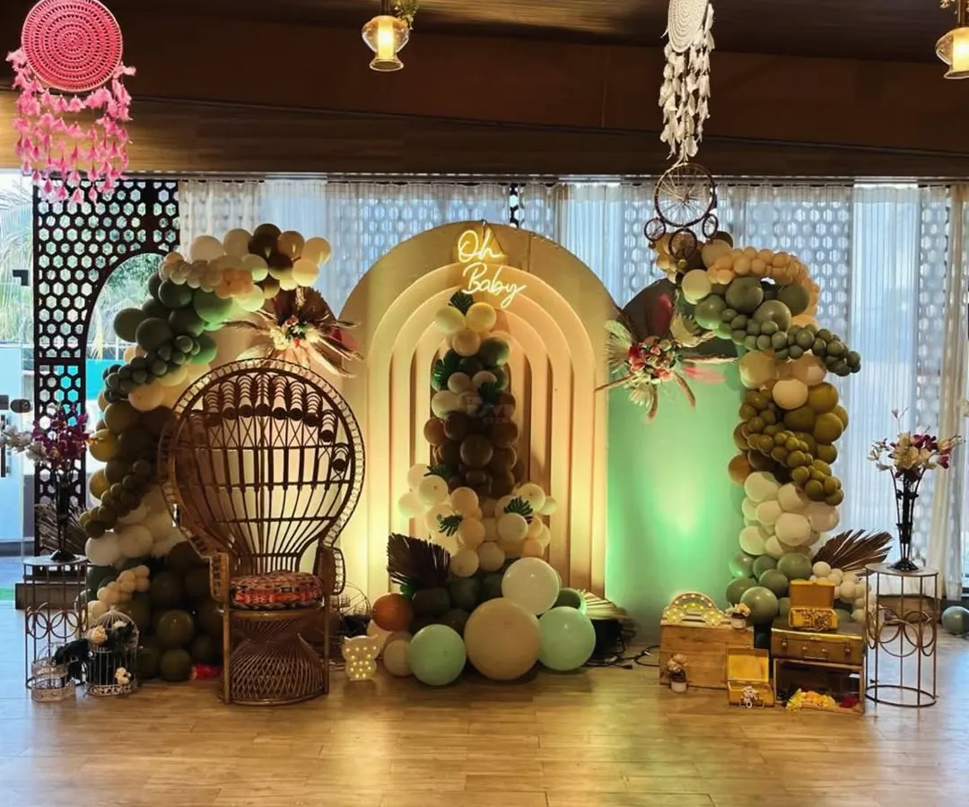 Our signature boho baby shower setup. We combined earthy-toned organic balloon arches with pampas grass and a custom "Oh Baby" neon sign to create a warm, inviting photo zone. The wicker peacock throne makes the mom-to-be the true center of attention.
