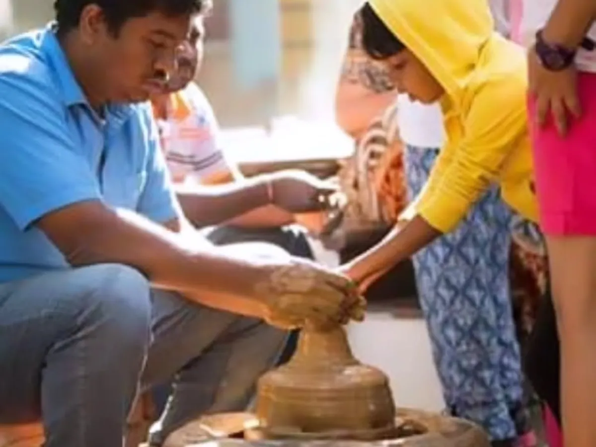 A child works with clay at a real pottery wheel, with an artisan guiding her hands. We arrange the pottery activity through our partners.