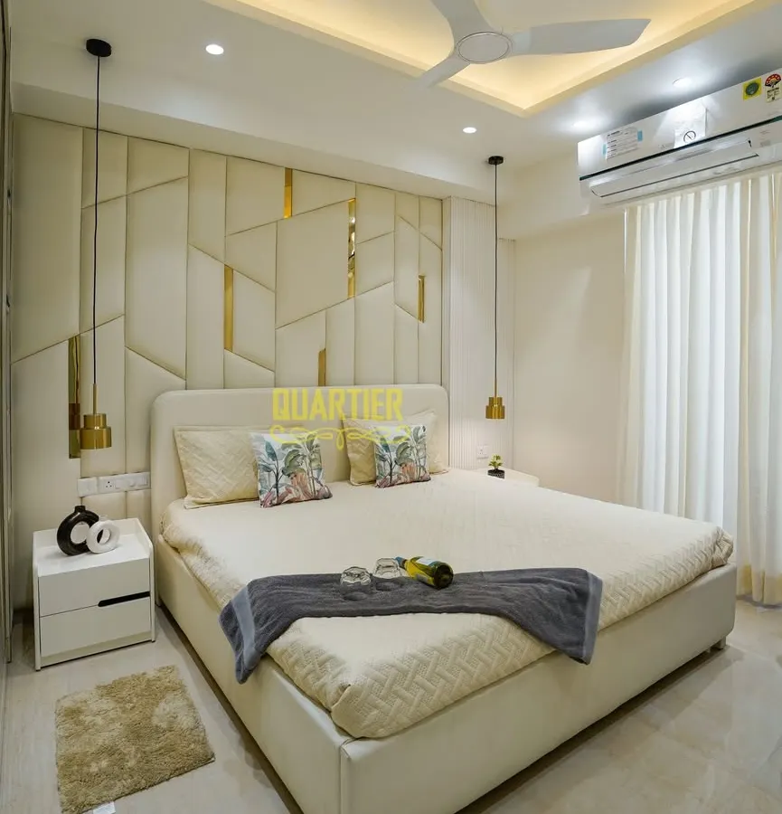 I believe a master bedroom should be a personal retreat. For this home in Tata LaVida, Gurugram, I designed a custom upholstered headboard with geometric patterns and gold inlays, complemented by soft pendant lighting to create a serene and luxurious atmosphere for rest and relaxation.