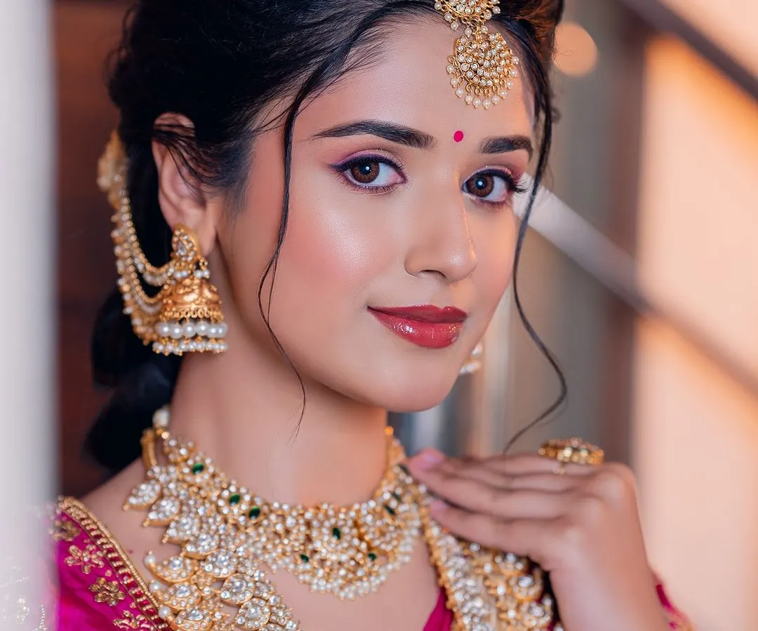 For this classic South Indian bridal look, I balanced traditional elements with a modern, dewy skin finish. The focus is on radiant skin, defined eyes, and a lip color that enhances her natural beauty.