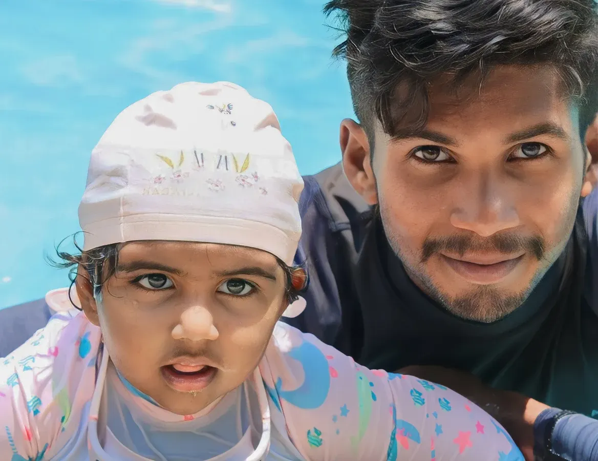 A close-up moment of trust between one of our certified coaches and a young swimmer. We believe early water exposure, guided with care, is the foundation for a lifetime of confidence in the pool.