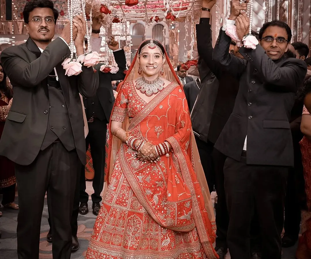 The bride's grand entrance under a traditional phoolon ki chaadar, held by her brothers. This is a classic wedding moment, filled with emotion and anticipation.