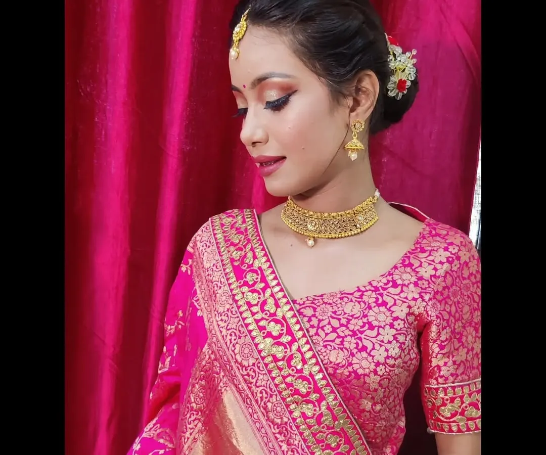 For this traditional look, I focused on creating sharp, defined eyes with winged liner and soft pink tones on the lips to complement the vibrant Banarasi lehenga. The hair is styled in a classic bun, adorned with fresh flowers for an authentic festive feel.