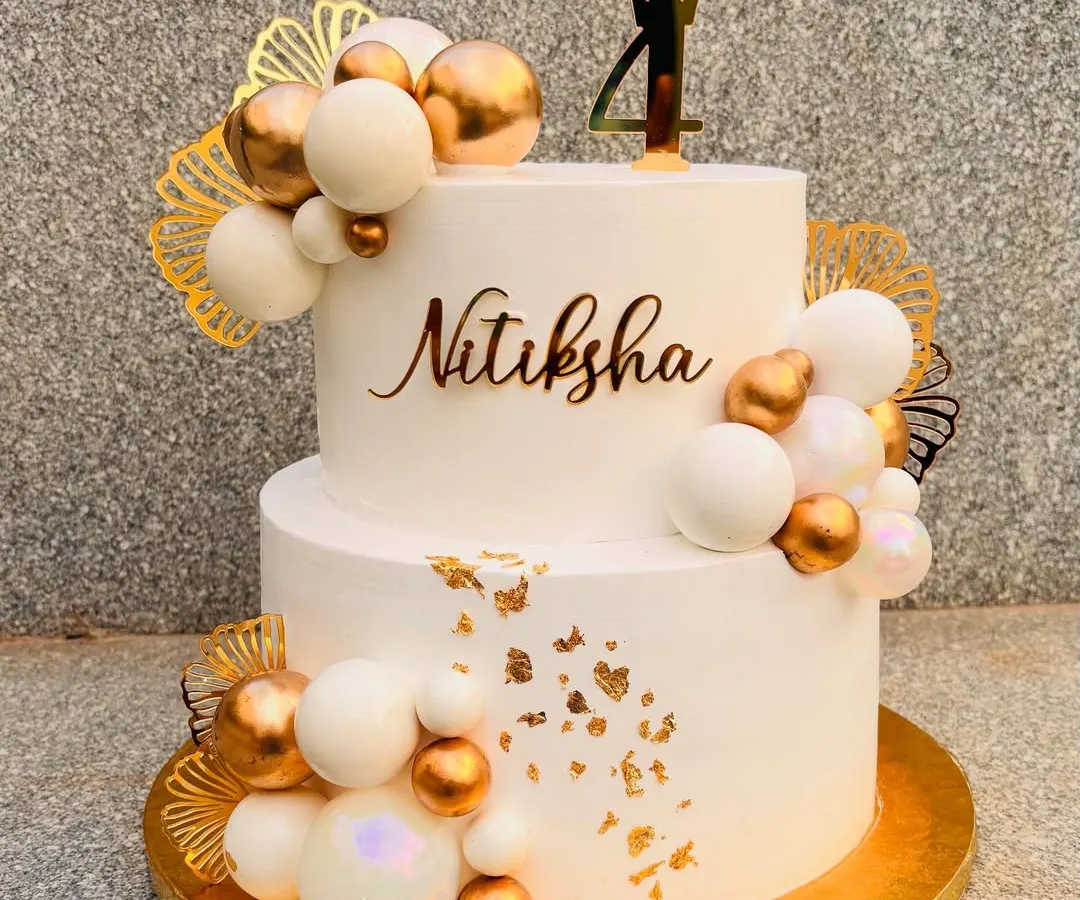 This was a 5-kilo beauty for a 4th birthday. I love creating these grand, elegant cakes with white and gold themes, using a mix of edible spheres, delicate gold leaf, and custom acrylic toppers to make it extra special.