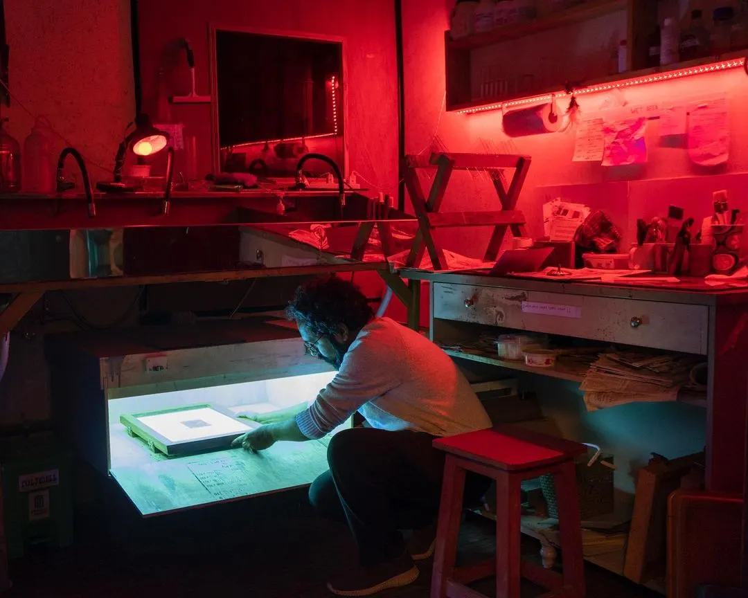 Here is a look inside our dedicated darkroom, illuminated by the glow of the UV lightbox. This space is the heart of our alternative photography offerings, fully equipped for processes like cyanotype, Vandyke brown, and gum bichromate printing.