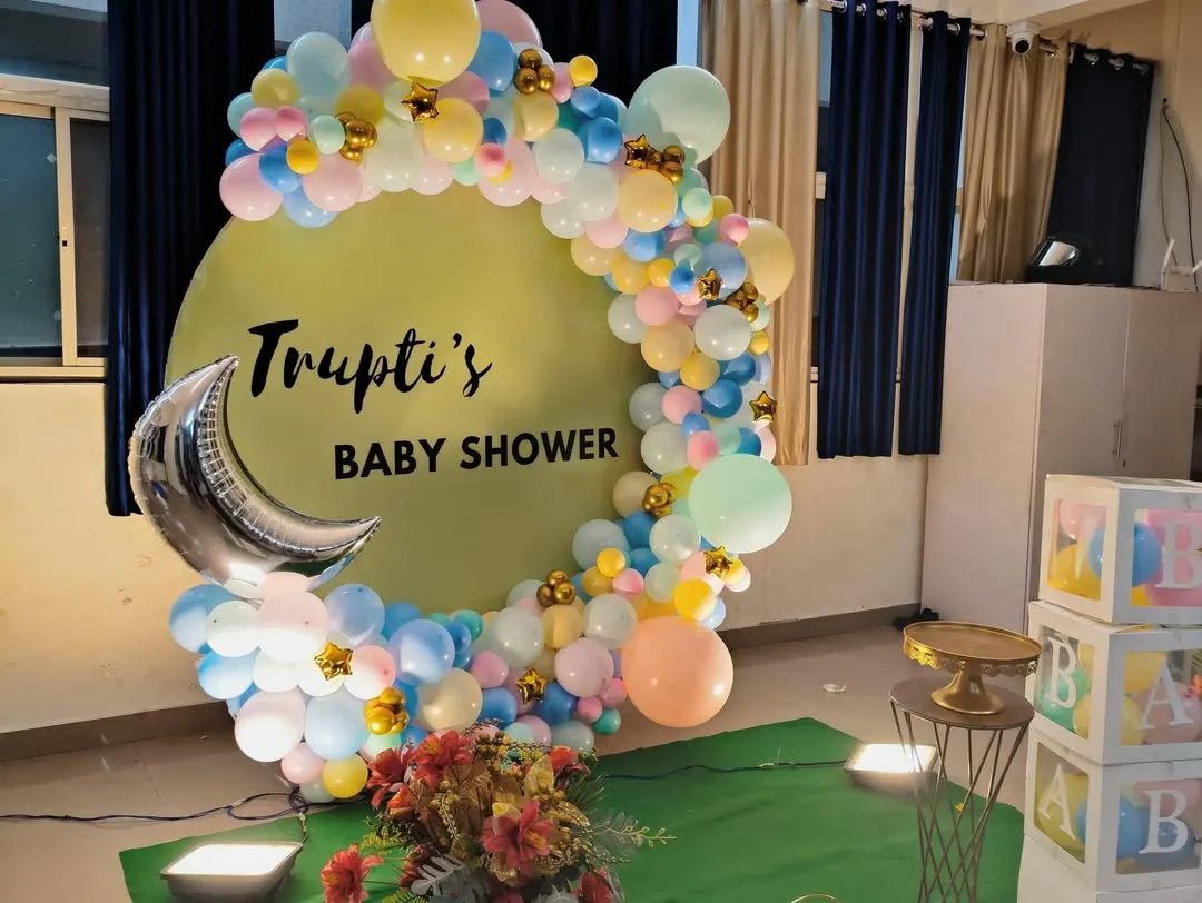 We create dreamy baby showers, like this one for Trupti. This setup includes a custom circular backdrop, a beautiful organic balloon arch in soft pastel colors, and a silver moon foil accent, creating a perfect photo opportunity.