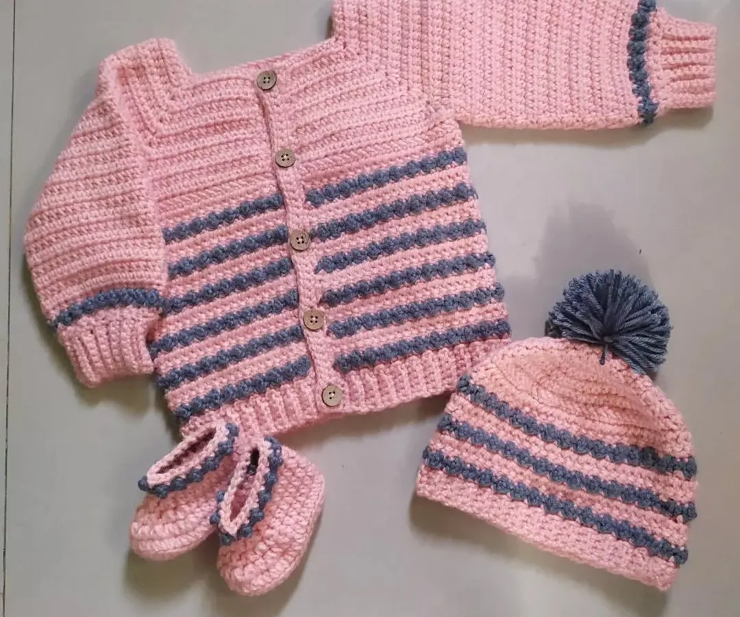 I love creating complete, coordinated outfits. This cozy winter set includes a striped cardigan with wooden buttons, a matching pom-pom beanie, and a pair of adorable booties, all handmade to keep your baby warm and stylish.