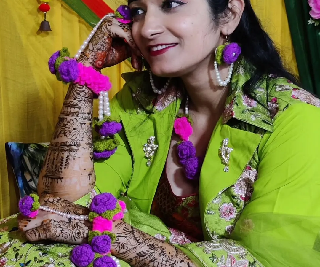 For the bride-to-be who wants something truly unique. I designed and created this custom crochet floral jewelry set for a mehndi ceremony. The set includes a maang tikka, earrings, and hathphool bracelets, all handmade with vibrant purple and pink yarn and detailed with pearls.