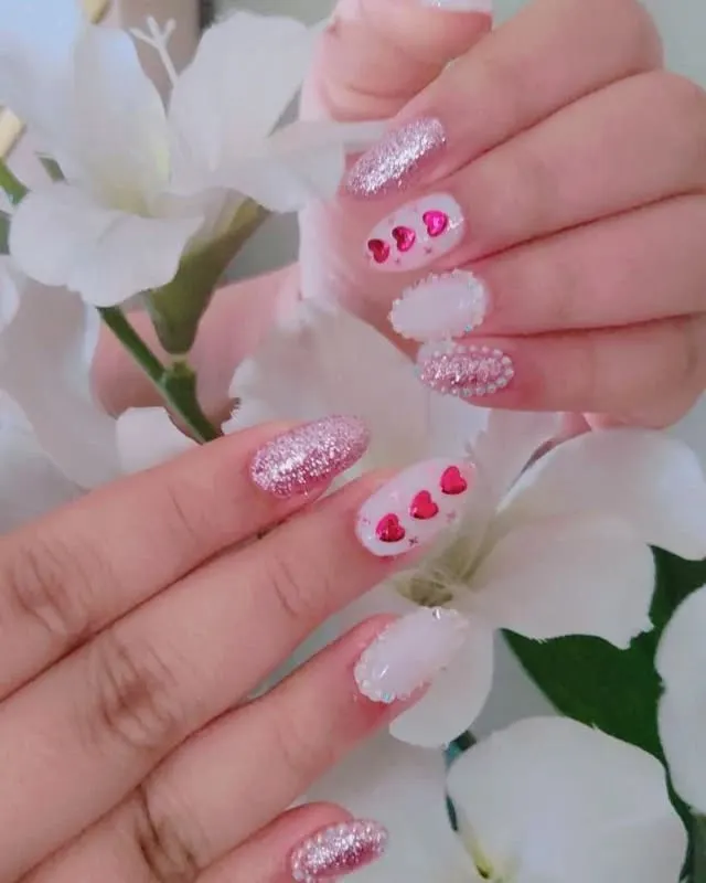 I had so much fun with this Valentine's Day themed set. It combines pink glitter, tiny red hearts, and full pearl accent nails for a look that is full of love and sparkle.