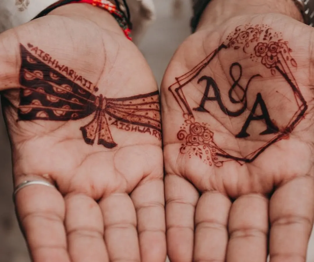I love this combination of modern and traditional for a groom's mehendi. On one palm, we have a clean, geometric frame with the couple's initials, and on the other, a classic groom's turban design. It’s the perfect balance of personal and stylish.