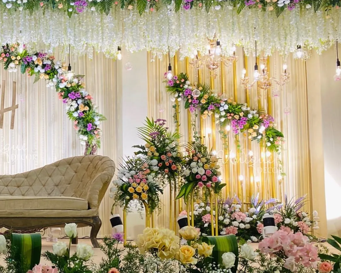 For a soft and romantic reception, I designed this stage with lush pastel florals, elegant chandeliers, and warm lighting. The hanging wisteria and dense flower arrangements create a dreamy, luxurious feel.