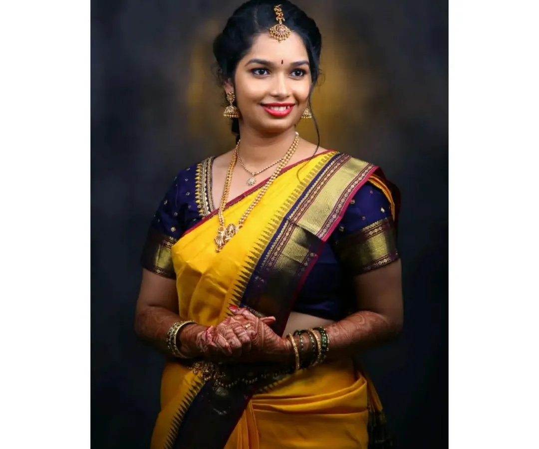 For this client's Varpooja ceremony, we chose a classic South Indian look. The makeup features defined eyes and a bright lip, complementing her beautiful yellow silk saree and traditional gold jewelry.