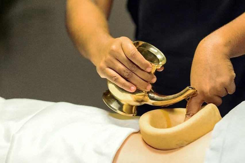 This is Kati Basti, one of our most effective treatments for chronic back pain and sciatica. A dam of herbal dough holds warm, medicated oil over the lower back, deeply nourishing the nerves and relieving stiffness.