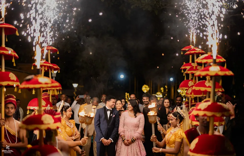 I believe every couple deserves a spectacular entrance. Here, we created a magical pathway with traditional umbrellas, torch-bearing dancers, and cold pyro sparklers to welcome the couple into their reception, making for an unforgettable moment.