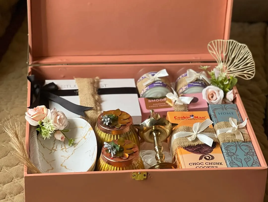 This premium hamper, presented in an elegant pink trunk box, is filled with luxury items like a marble-patterned tray, gourmet cookies, and scented candles. It’s designed for those moments that call for an extra touch of class and sophistication.
