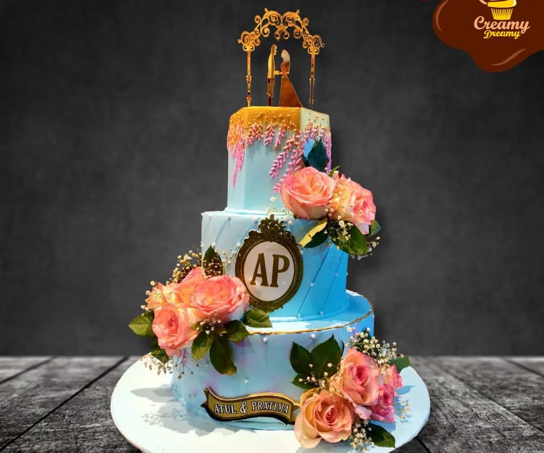 For this three-tier engagement cake, I used a soft blue buttercream and adorned it with fresh peach roses and a custom monogram. The gold drip and elegant topper add a touch of luxury to celebrate the couple's new beginning.