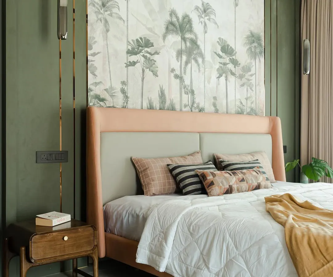 I believe a bedroom should be a personal sanctuary. Here, a stunning tropical wallpaper serves as an art piece, creating a serene backdrop for the custom-upholstered bed. The combination of soft textures, layered lighting, and bespoke furniture transforms this room into a tranquil escape.