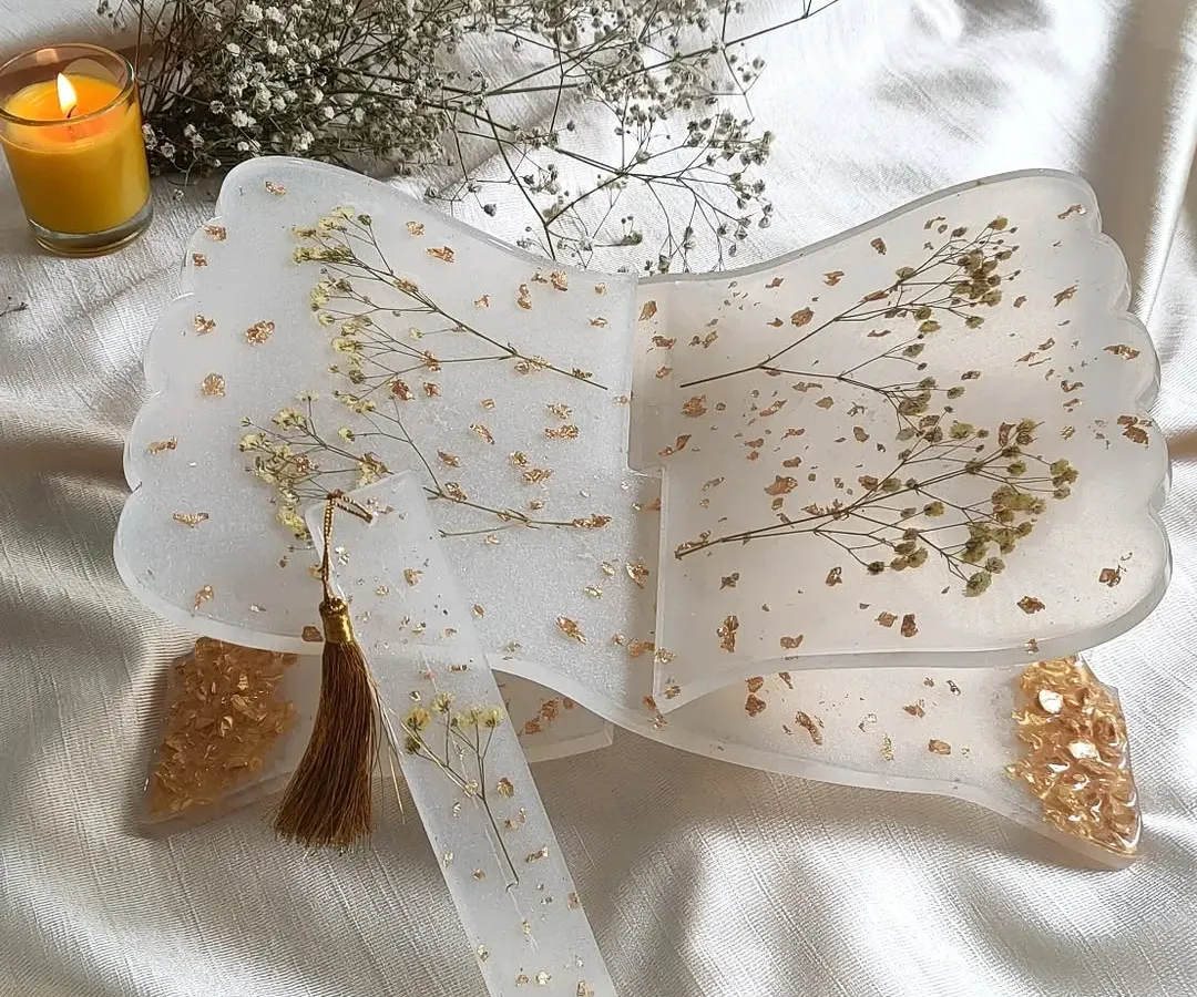This is my resin holy book stand, or rihal, designed to be both beautiful and functional. I've embedded delicate sprigs of baby's breath and scattered gold flakes into the clear resin, creating a serene and elegant piece for your daily prayers or reading. It also comes with a matching bookmark.