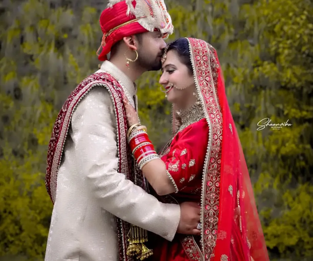 A tender moment from a Himachali wedding shoot. Capturing the quiet connection between a couple is what makes a wedding album special. This outdoor portrait highlights the beautiful traditional attire against a natural green background.