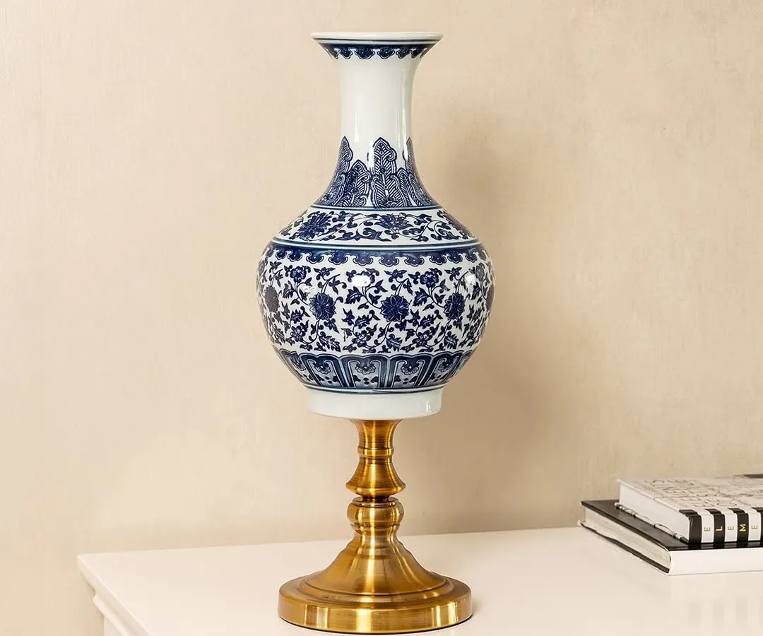 This blue pottery vase is a perfect example of the timeless craftsmanship I look for. The deep cobalt blue and intricate floral patterns are hand-painted, set on a modern brass stand to blend traditional art with contemporary design. It's a statement piece for any console or side table.