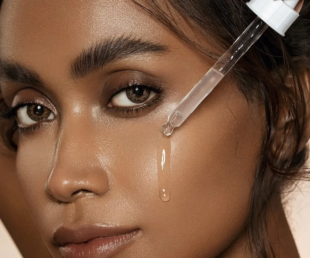 I believe in celebrating real skin. This close-up shot focuses on a dewy, hydrated complexion, capturing the precise moment a serum drop touches the skin. It’s a testament to my philosophy of minimal intervention and letting the product's effect speak for itself, highlighting texture and a natural, luminous glow.