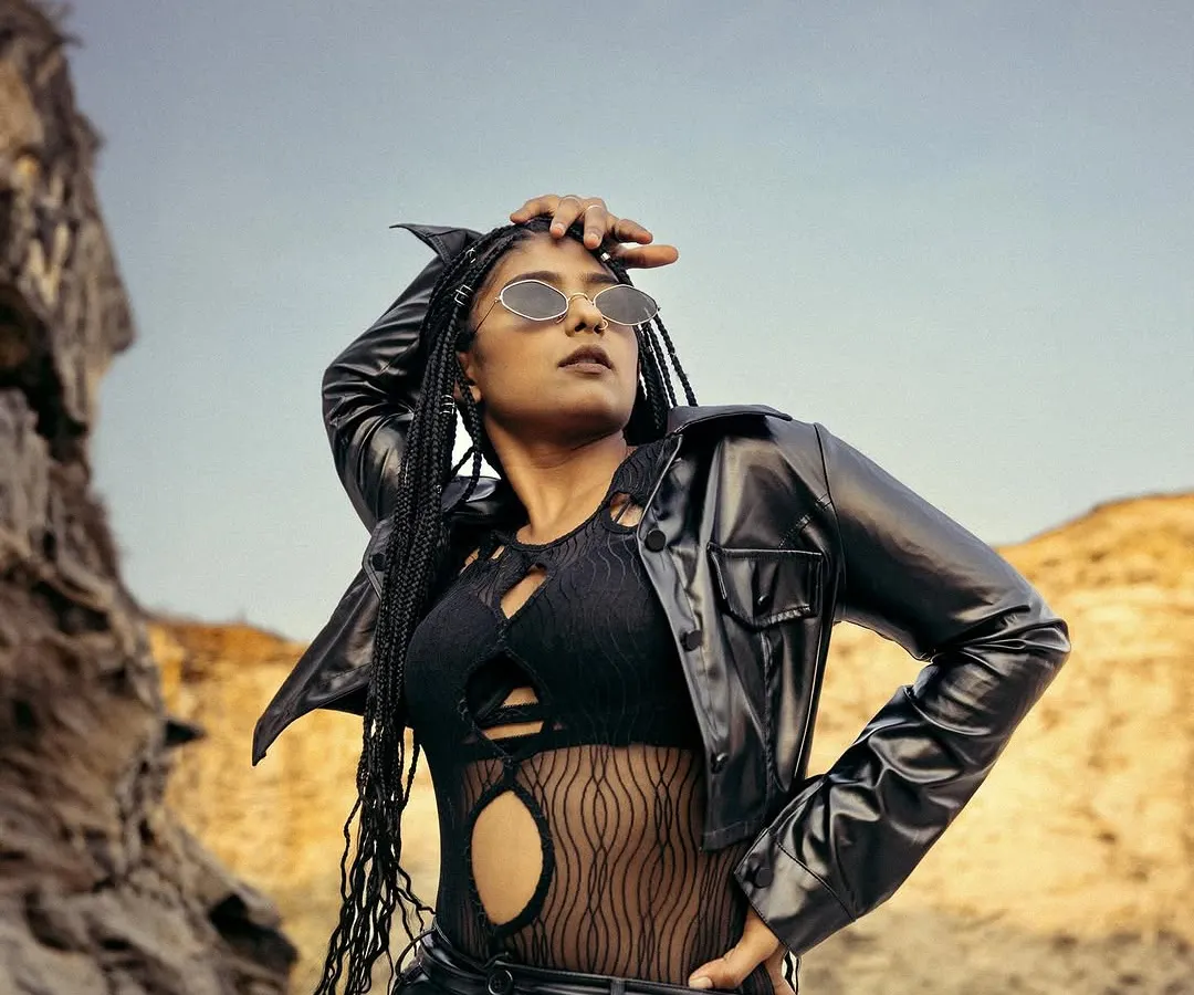 This image captures a bold, edgy aesthetic for an outdoor fashion campaign. The model's strong pose in a black leather outfit against a rugged rock formation demonstrates our ability to create powerful, narrative-driven visuals on location.