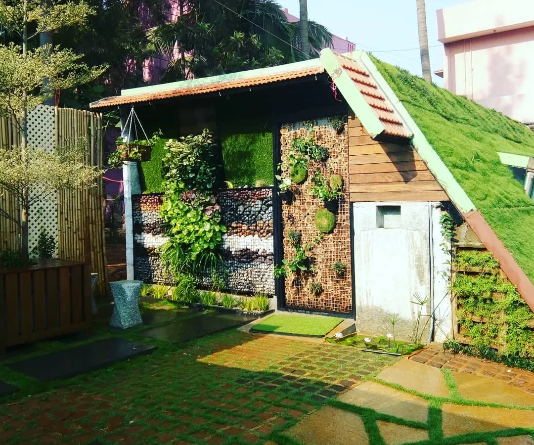 This project was a joy to create, combining several green concepts into one small space. I built a grass-covered roof, installed vertical planters on the walls, and used grass pavers for a functional and completely green walkway.