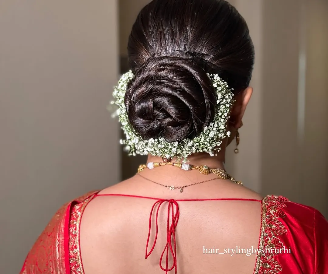 This is a detailed look at a floral rose bun, crafted with precision and encircled by delicate baby's breath. It's a popular and elegant choice for brides and is suitable for receptions and other formal events.