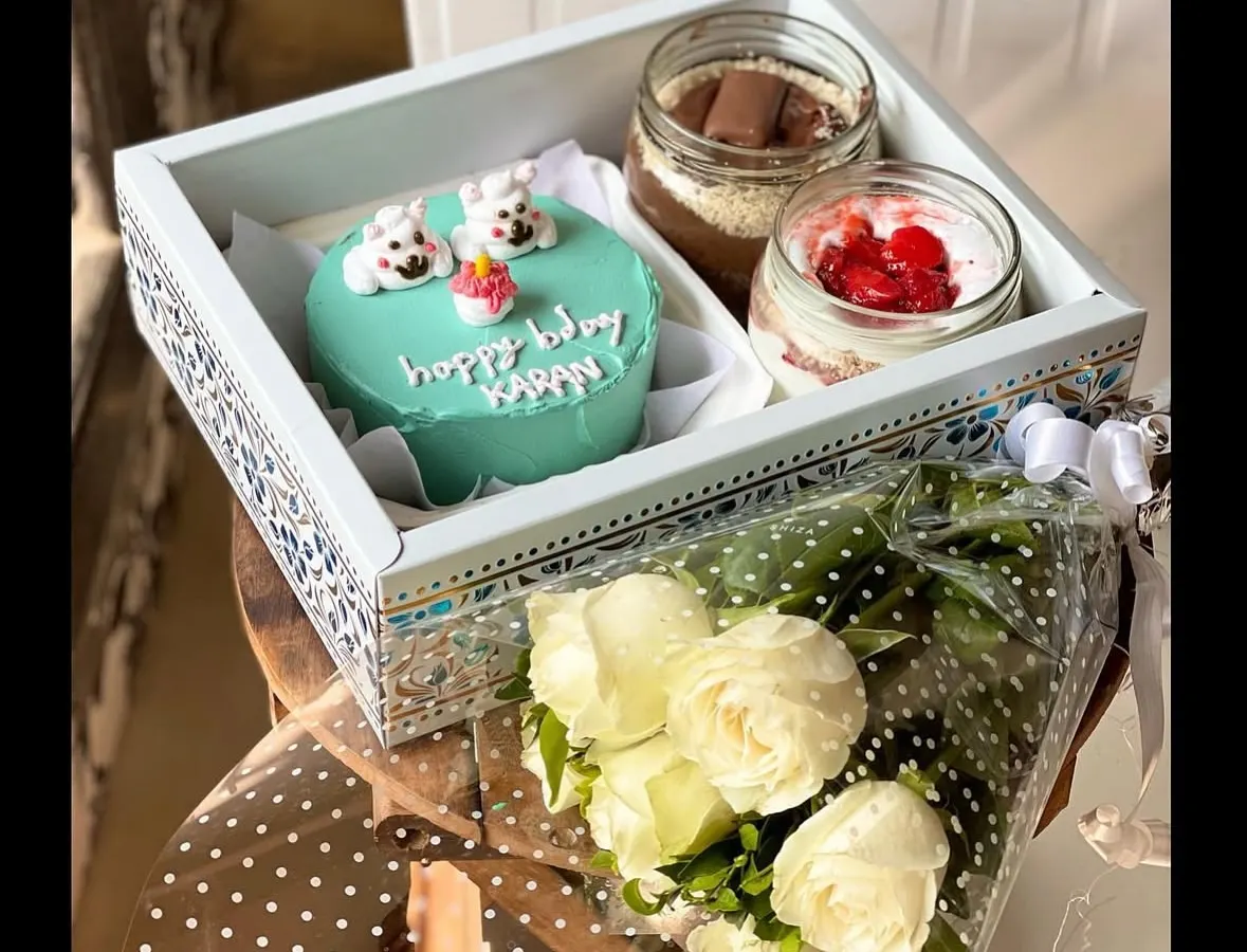 For the ultimate gift, I offer this beautiful hamper. It features a custom light blue bento cake with adorable polar bears, two delicious cake jars, and a fresh bouquet of white roses, all presented in an elegant, decorated tray.